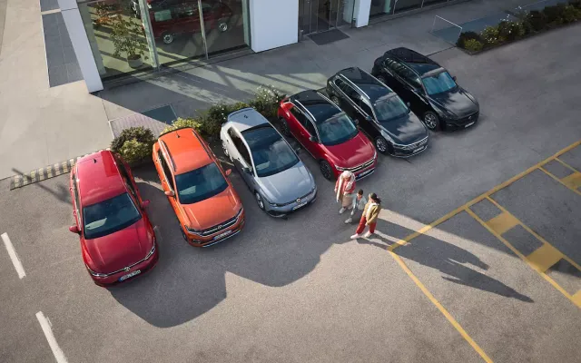 Happy drivers next to their older Volkswagen models