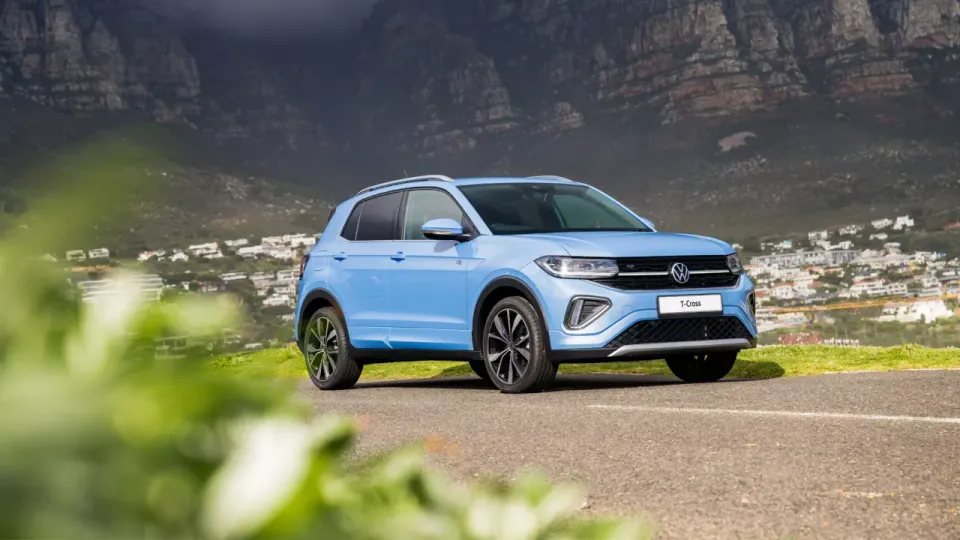 Volkswagen T-Cross parked on a hillside above a coastal town